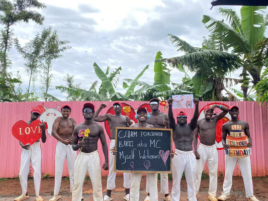African dancers in traditional attire performing at a joyful outdoor birthday celebration